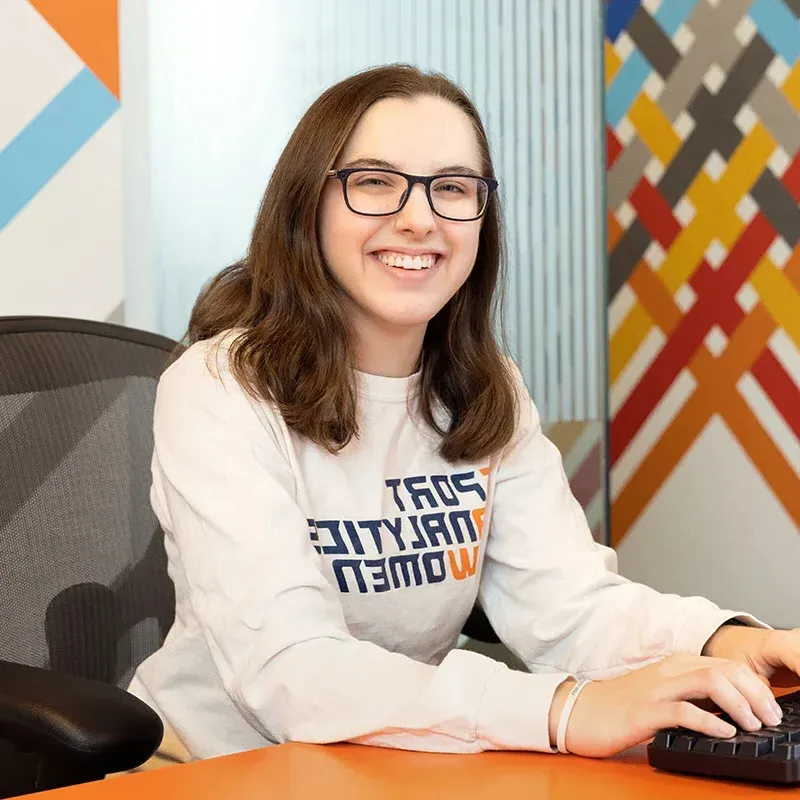 Alison Gilmore sitting at a desk and smiling.