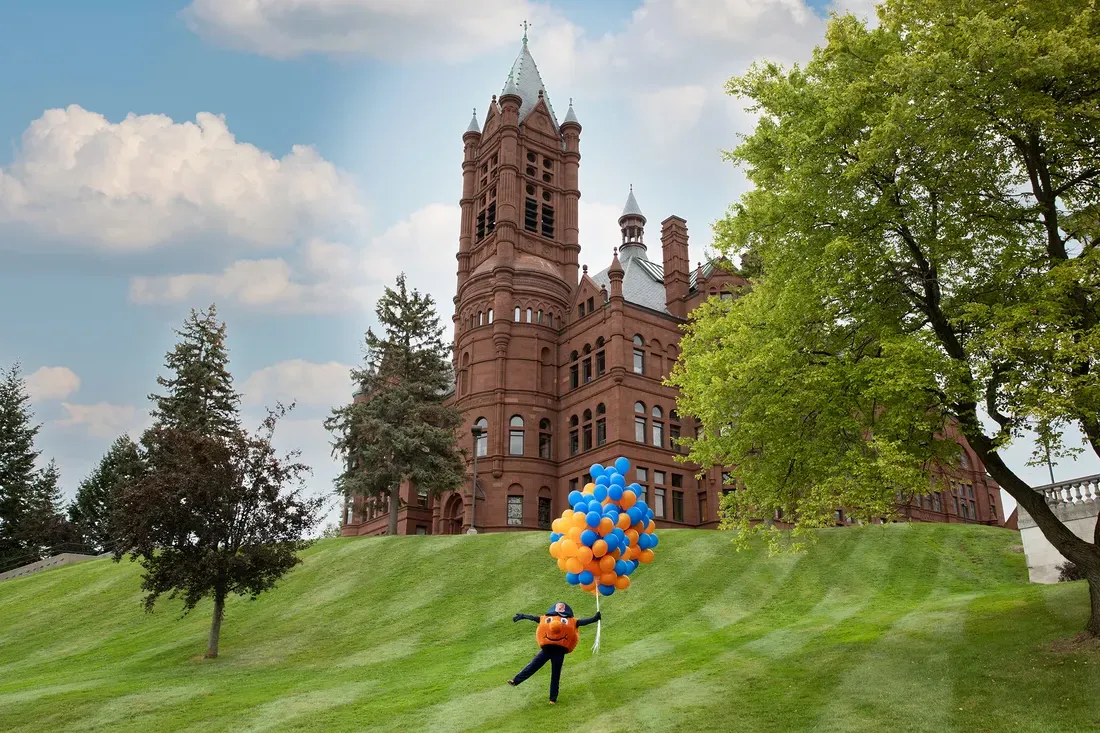 Otto in front of Crouse Hall holding balloons.